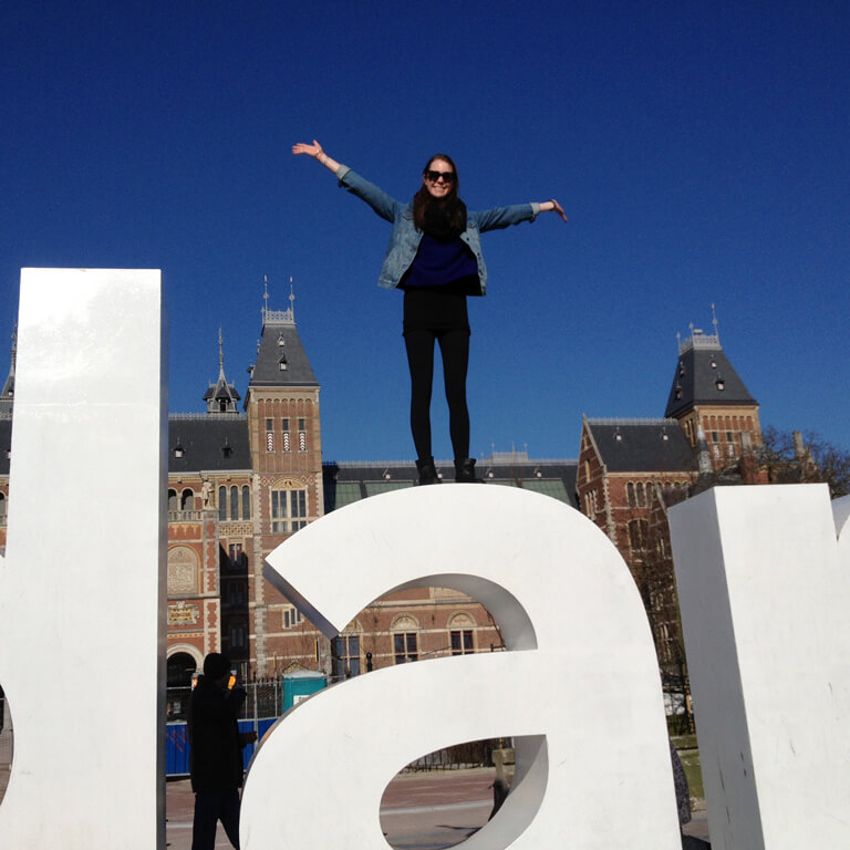 A student posing on top of giant letters during a Study abroad in Amsterdam.